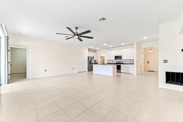 6700 NW Omega Rd, Port Saint Lucie, FL 34983 - unfurnished living room with a ceiling fan, arched walkways, recessed lighting, and light tile patterned floors