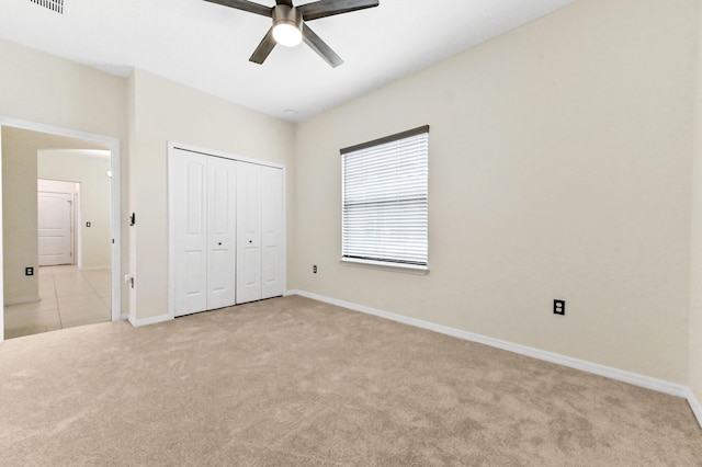 6700 NW Omega Rd, Port Saint Lucie, FL 34983 - unfurnished bedroom with light colored carpet, a closet, baseboards, and a ceiling fan