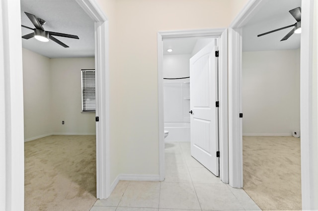 6700 NW Omega Rd, Port Saint Lucie, FL 34983 - hallway with light colored carpet, baseboards, and light tile patterned floors