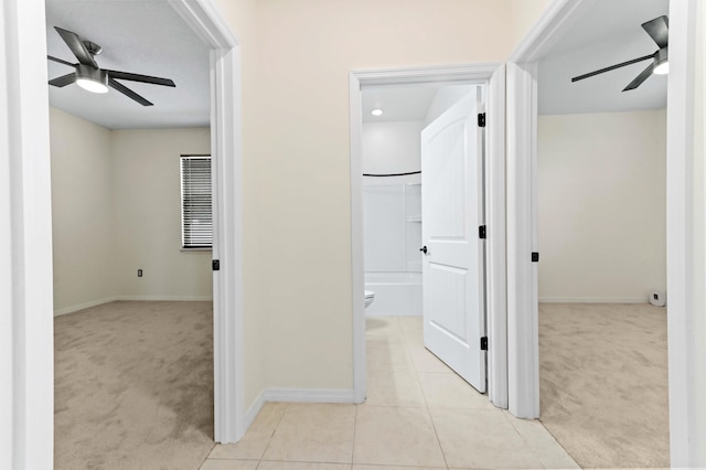 6700 NW Omega Rd, Port Saint Lucie, FL 34983 - hallway featuring carpet flooring, baseboards, and tile patterned floors