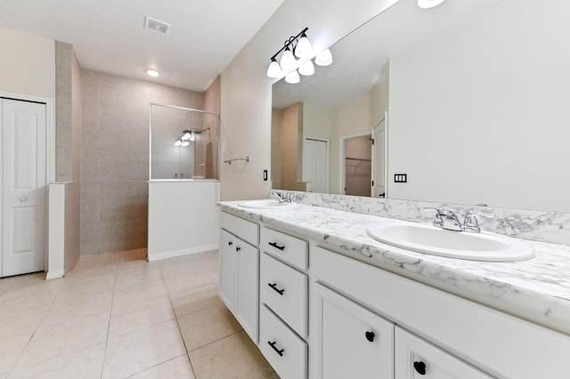 6700 NW Omega Rd, Port Saint Lucie, FL 34983 - bathroom with double vanity, a walk in shower, tile patterned flooring, and baseboards