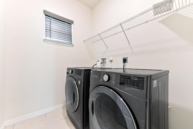 6700 NW Omega Rd, Port Saint Lucie, FL 34983 - laundry area featuring washing machine and dryer, baseboards, and light tile patterned flooring