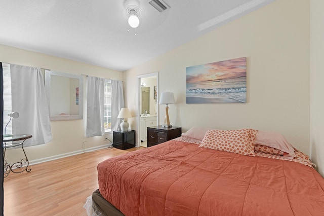 716 21st St, West Palm Beach, FL 33407 - bedroom with wood finished floors, baseboards, vaulted ceiling, a ceiling fan, and ensuite bath