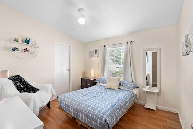 716 21st St, West Palm Beach, FL 33407 - bedroom with wood finished floors, a wall unit AC, and baseboards