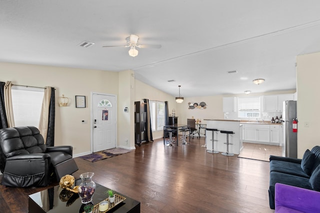 716 21st St, West Palm Beach, FL 33407 - living room with healthy amount of natural light, vaulted ceiling, a ceiling fan, wood finished floors, and baseboards