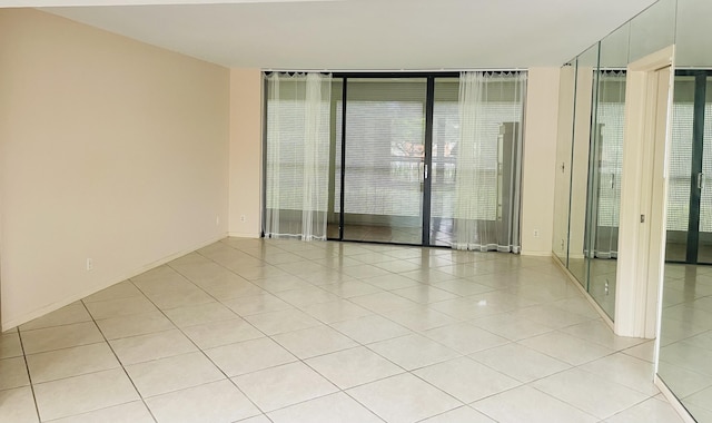 2520 Presidential Way Unit 205, West Palm Beach, FL 33401 - spare room featuring light tile patterned floors, healthy amount of natural light, and floor to ceiling windows