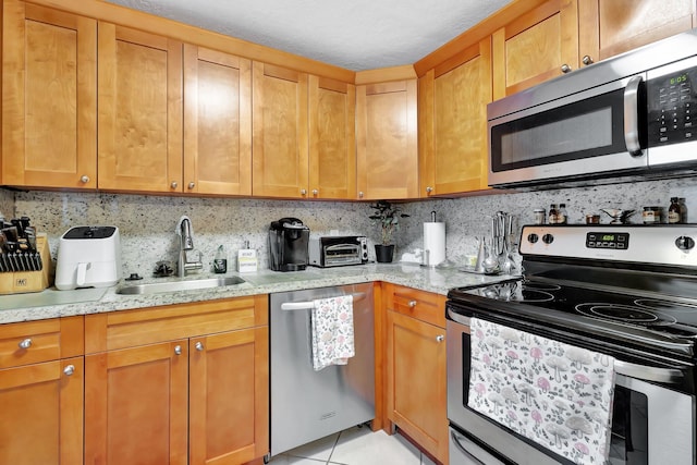 637 N Monaco N Unit 637, Delray Beach, FL 33446 - kitchen with appliances with stainless steel finishes, a sink, backsplash, light stone countertops, and light tile patterned flooring