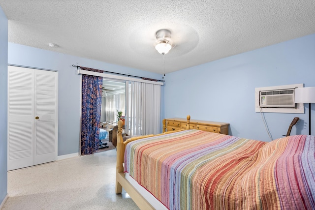 590 SE Anchor Ln, Port Saint Lucie, FL 34983 - bedroom with speckled floor, a wall mounted air conditioner, a textured ceiling, a closet, and ceiling fan