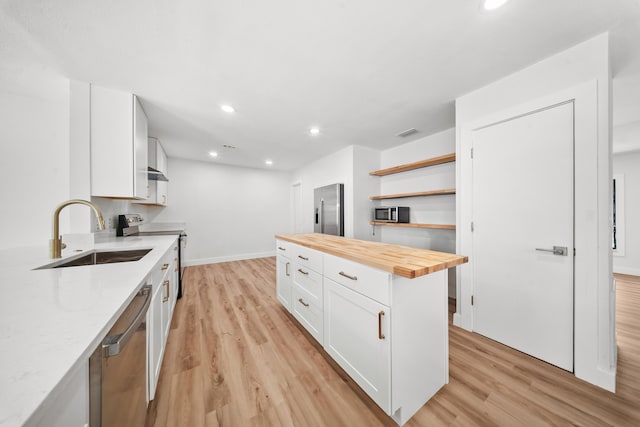 948 Canal Cir, Sebastian, FL 32958 - kitchen featuring butcher block countertops, appliances with stainless steel finishes, light wood finished floors, white cabinetry, and recessed lighting