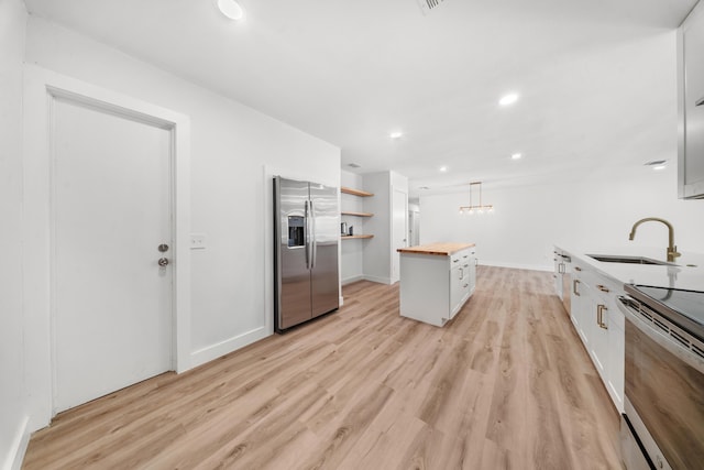948 Canal Cir, Sebastian, FL 32958 - kitchen featuring appliances with stainless steel finishes, wooden counters, light wood-style floors, open shelves, and a kitchen island