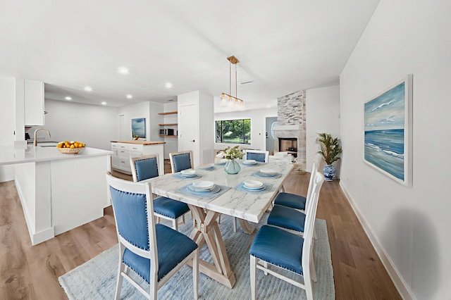 948 Canal Cir, Sebastian, FL 32958 - dining room featuring light wood finished floors, a stone fireplace, and recessed lighting