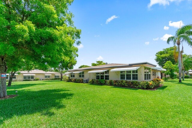 1012 Circle Ter E Unit A, Delray Beach, FL 33445 - back of property featuring a lawn and stucco siding