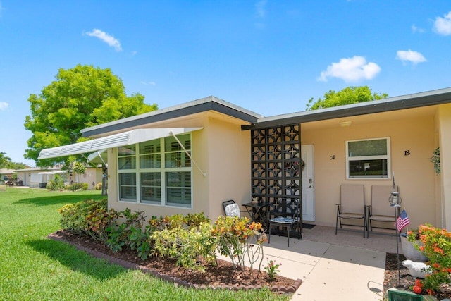 1012 Circle Ter E Unit A, Delray Beach, FL 33445 - property entrance with a yard, a patio area, and stucco siding