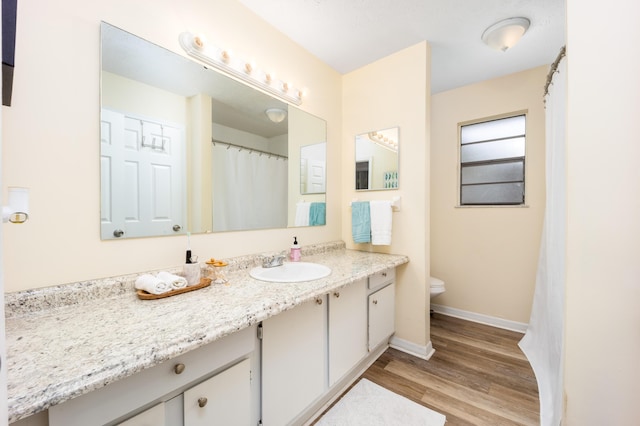 782 NW Kilpatrick Ave, Port Saint Lucie, FL 34983 - full bathroom featuring toilet, vanity, wood finished floors, and baseboards