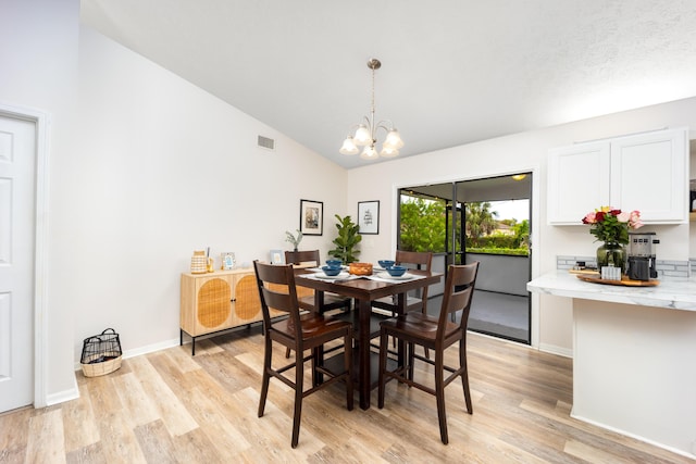 782 NW Kilpatrick Ave, Port Saint Lucie, FL 34983 - dining space featuring light wood-style flooring, a chandelier, baseboards, and high vaulted ceiling