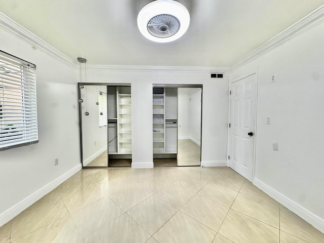 6074 Forest Hill Blvd Unit 107, West Palm Beach, FL 33415 - unfurnished bedroom featuring tile patterned floors, crown molding, multiple closets, and baseboards