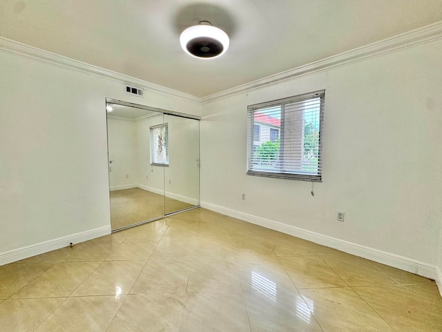 6074 Forest Hill Blvd Unit 107, West Palm Beach, FL 33415 - unfurnished bedroom with ornamental molding, baseboards, a closet, and light tile patterned flooring