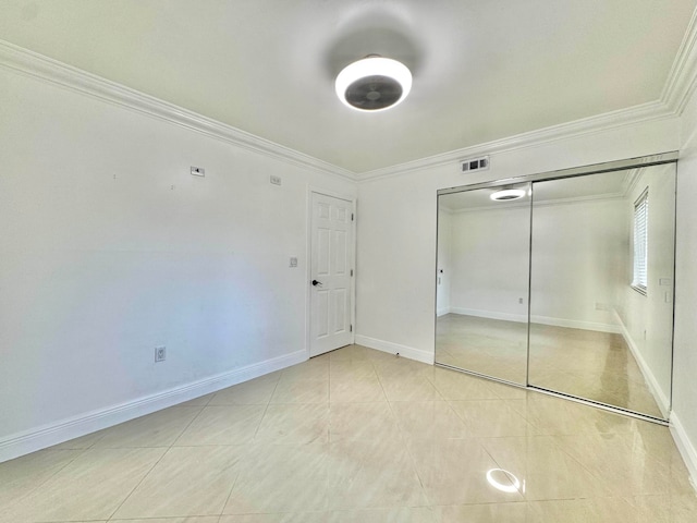 6074 Forest Hill Blvd Unit 107, West Palm Beach, FL 33415 - unfurnished bedroom featuring ornamental molding, light tile patterned floors, a closet, and baseboards