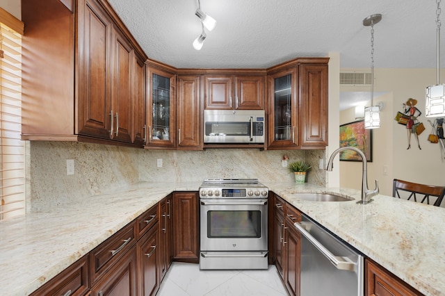 213 Piedmont E, Delray Beach, FL 33484 - kitchen with stainless steel appliances, a sink, light stone counters, decorative backsplash, and a textured ceiling