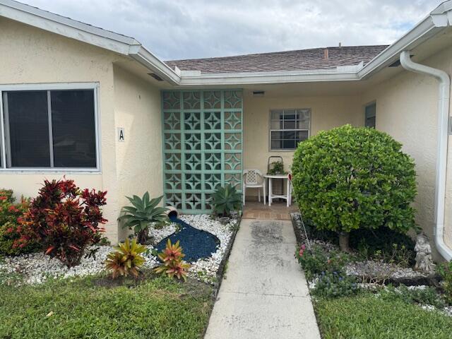 5397 Lakefront Blvd Unit A, Delray Beach, FL 33484 - doorway to property featuring stucco siding and roof with shingles