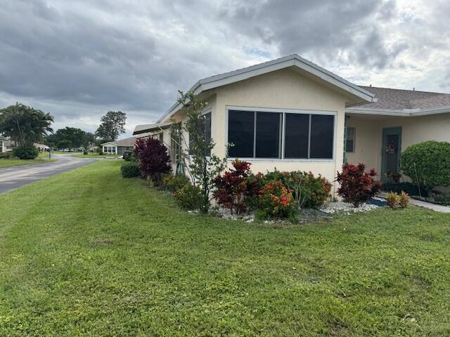 5397 Lakefront Blvd Unit A, Delray Beach, FL 33484 - view of side of home featuring a lawn and stucco siding