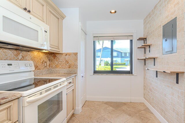 2641 Gately Dr W Unit 1003, West Palm Beach, FL 33415 - kitchen featuring white appliances, cream cabinetry, electric panel, and baseboards