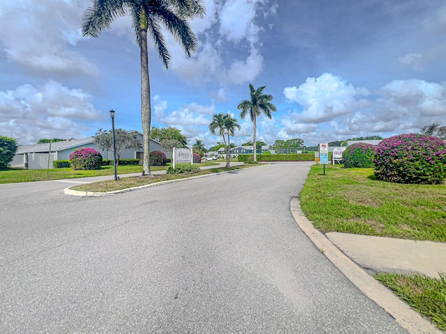 2641 Gately Dr W Unit 1003, West Palm Beach, FL 33415 - view of asphalt road with street lights and a residential view