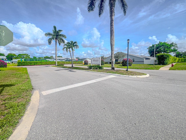 2641 Gately Dr W Unit 1003, West Palm Beach, FL 33415 - view of asphalt road featuring street lights and curbs