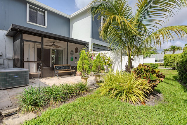 2641 Gately Dr W Unit 1003, West Palm Beach, FL 33415 - rear view of property featuring central AC unit, a ceiling fan, a patio area, a sunroom, and a lawn