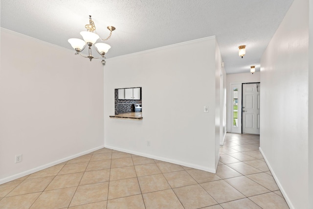 5835 Honeybell Ct Unit 37, Fort Pierce, FL 34982 - empty room featuring a chandelier, light tile patterned flooring, a textured ceiling, baseboards, and ornamental molding