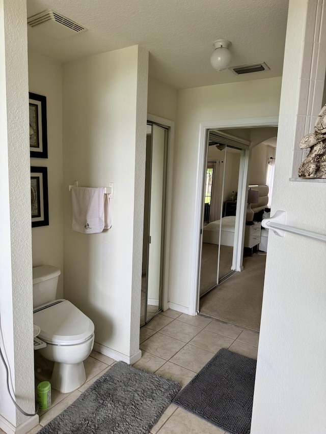 1710 SW Columbia St, Port Saint Lucie, FL 34987 - bathroom featuring toilet, tile patterned floors, and a textured ceiling