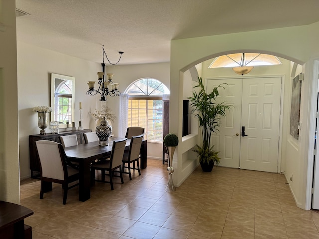 1710 SW Columbia St, Port Saint Lucie, FL 34987 - dining area featuring arched walkways, a chandelier, light tile patterned floors, and baseboards