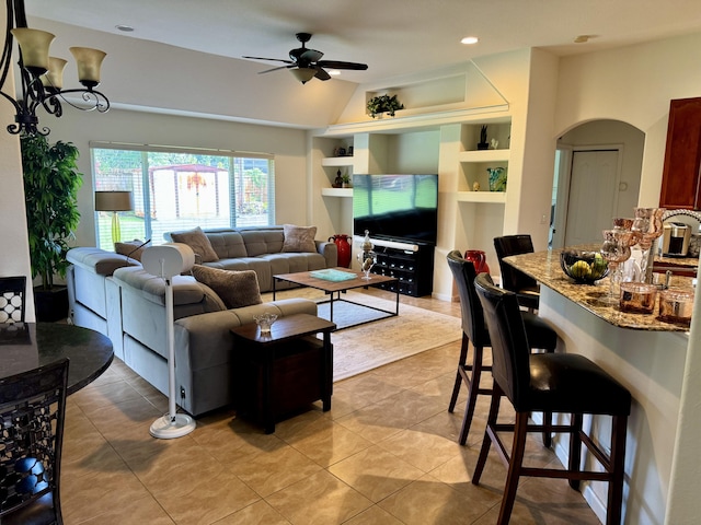 1710 SW Columbia St, Port Saint Lucie, FL 34987 - living room with built in features, ceiling fan, arched walkways, light tile patterned floors, and vaulted ceiling