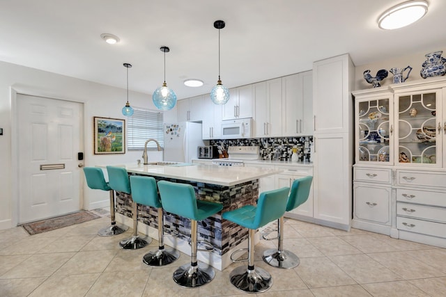 1232 W Club Dr W Unit D, Delray Beach, FL 33445 - kitchen featuring white appliances, light countertops, a sink, and light tile patterned flooring