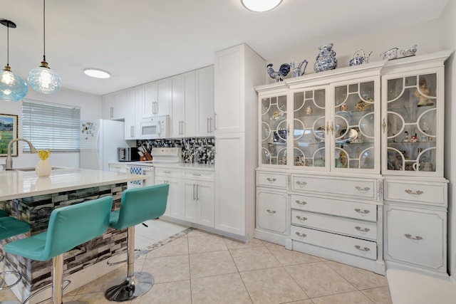 1232 W Club Dr W Unit D, Delray Beach, FL 33445 - kitchen featuring white appliances, a sink, light tile patterned floors, light countertops, and backsplash