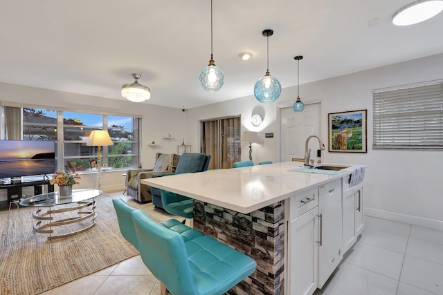 1232 W Club Dr W Unit D, Delray Beach, FL 33445 - kitchen featuring light tile patterned flooring, baseboards, white cabinetry, open floor plan, and pendant lighting