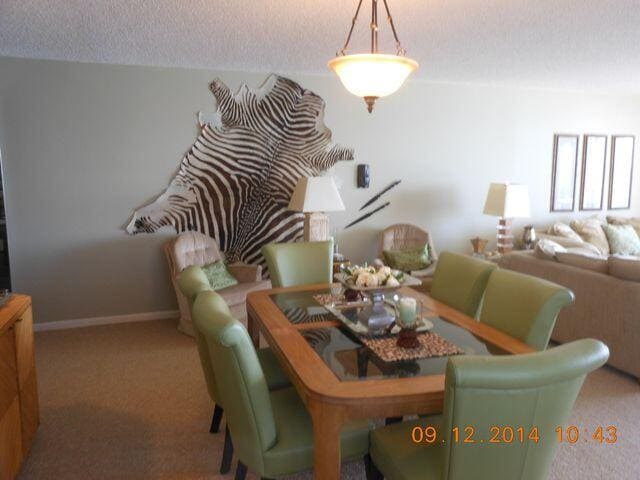4200 S Ocean Blvd Unit 503, South Palm Beach, FL 33480 - dining area featuring a textured ceiling, carpet flooring, and baseboards