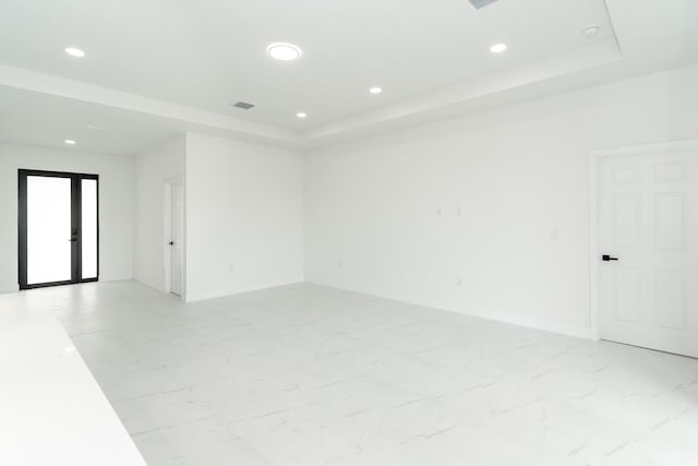 3810 29th St SW, Lehigh Acres, FL 33976 - unfurnished room featuring a tray ceiling, recessed lighting, light marble finish flooring, and baseboards