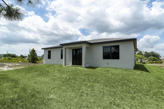 3810 29th St SW, Lehigh Acres, FL 33976 - back of house featuring stucco siding, french doors, and a lawn