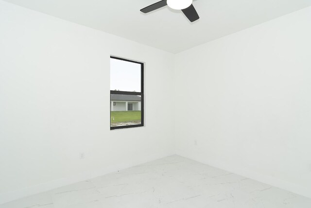 3810 29th St SW, Lehigh Acres, FL 33976 - spare room with marble finish flooring, ceiling fan, and baseboards