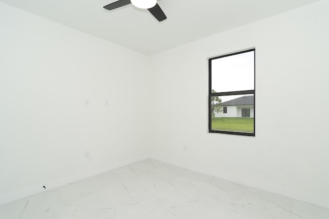 3810 29th St SW, Lehigh Acres, FL 33976 - spare room featuring marble look tiles, baseboards, and ceiling fan