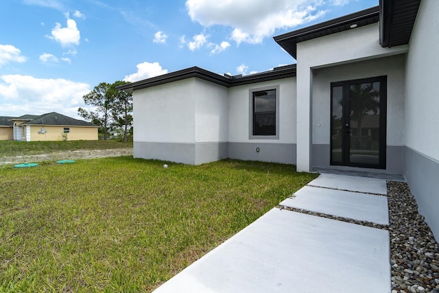 3810 29th St SW, Lehigh Acres, FL 33976 - property entrance with stucco siding and a yard