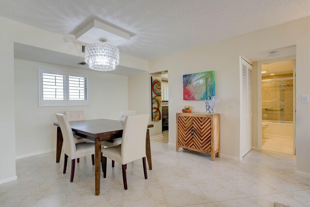 400 Ocean Trail Way Unit 707, Jupiter, FL 33477 - dining space featuring a chandelier, a textured ceiling, and baseboards