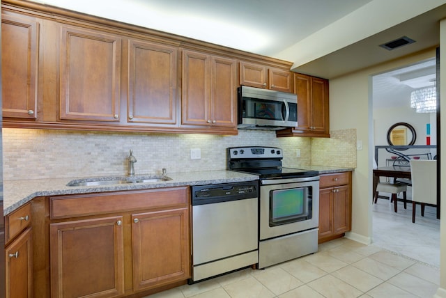 400 Ocean Trail Way Unit 707, Jupiter, FL 33477 - kitchen featuring appliances with stainless steel finishes, a sink, brown cabinets, and light stone counters