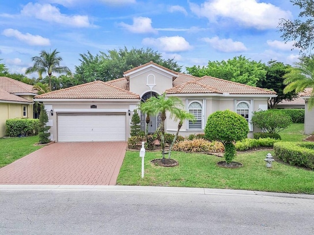 8351 Mastic Cay, West Palm Beach, FL 33411 - mediterranean / spanish home with a garage, decorative driveway, stucco siding, a front lawn, and a tiled roof