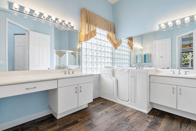 8351 Mastic Cay, West Palm Beach, FL 33411 - full bathroom featuring two vanities, wood finished floors, a stall shower, and a garden tub