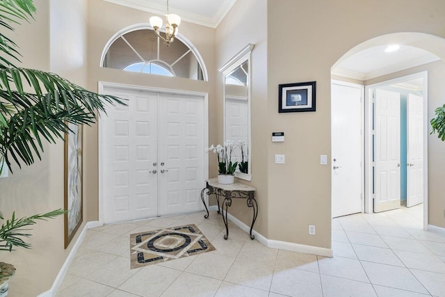 8351 Mastic Cay, West Palm Beach, FL 33411 - foyer entrance with ornamental molding, arched walkways, light tile patterned flooring, and baseboards