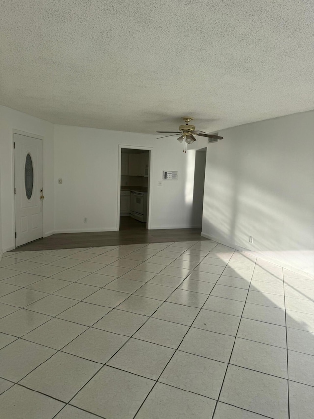 10789 N Military Trl Unit 3, Palm Beach Gardens, FL 33410 - empty room featuring a textured ceiling, ceiling fan, light tile patterned flooring, and baseboards