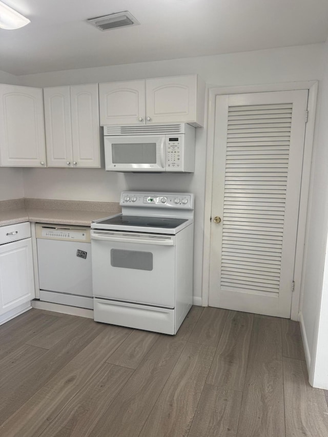 10789 N Military Trl Unit 3, Palm Beach Gardens, FL 33410 - kitchen with white appliances, dark wood-style flooring, white cabinets, and light countertops