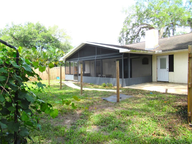 334 Brookedge Ter, Sebastian, FL 32958 - back of property featuring a sunroom, a chimney, a patio, stucco siding, and roof with shingles